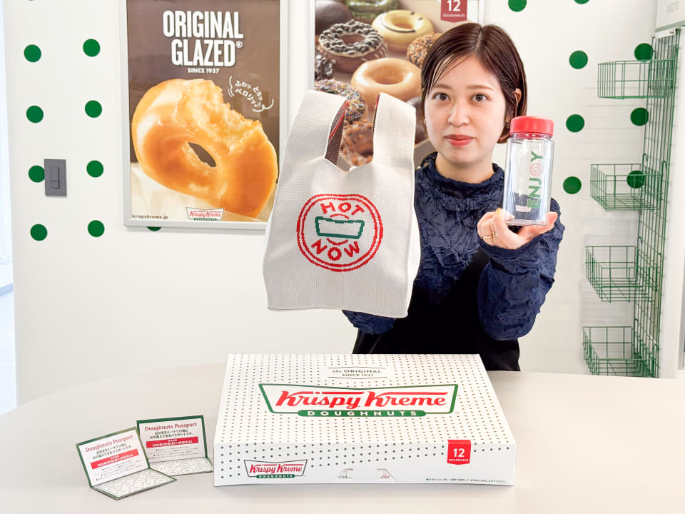 クリスピークリーム福袋2026のプレミアムセット。ニットのミニバッグ、クリアボトル、12個入りの箱、ドーナツパスポート2枚が並んでいる